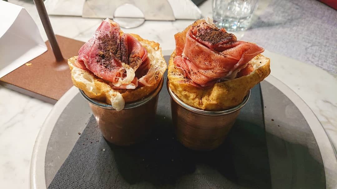 Ananascosta: cono con fonduta di Grana Padano DOP 12 mesi, prosciutto crudo, ananas e polvere di liquirizia
