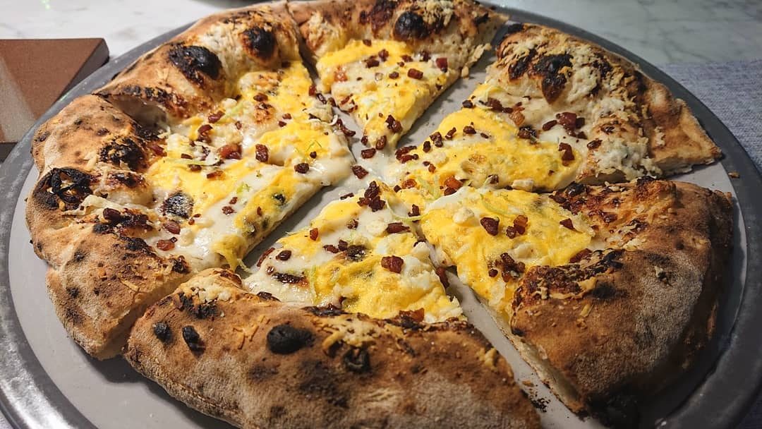 Pepe in Grani | Fonduta di Grana Padano DOP 12 mesi, scamorza affumicata, tuorlo d’uovo pastorizzato, bacon affumicato, pecorino romano sul cornicione, chips di Grana Padano DOP 24 mesi, pepe e zest di lime