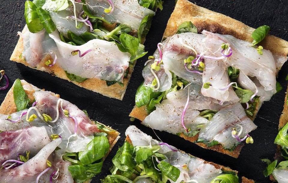 pizza bianca, songino, carpaccio di spigola e vinaigrette al Gin mare